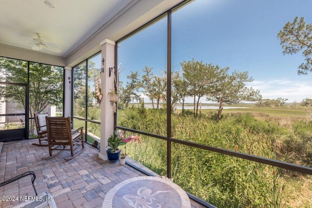 unfurnished sunroom featuring ceiling fan