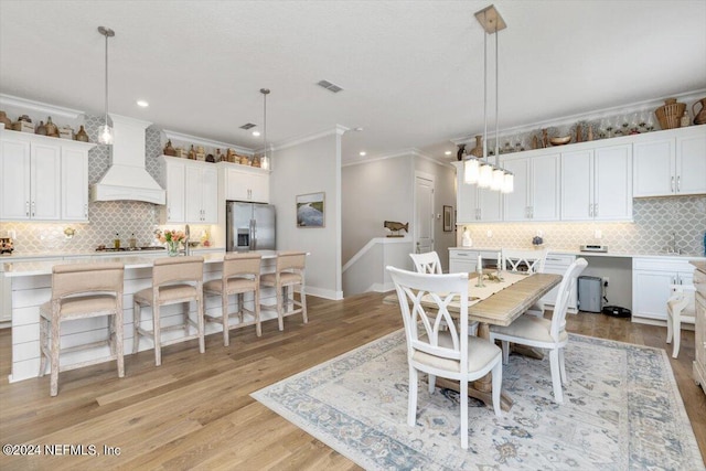 dining room featuring crown molding and light hardwood / wood-style floors