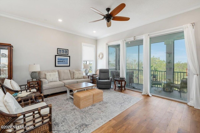 living room featuring hardwood / wood-style flooring, ceiling fan, and ornamental molding