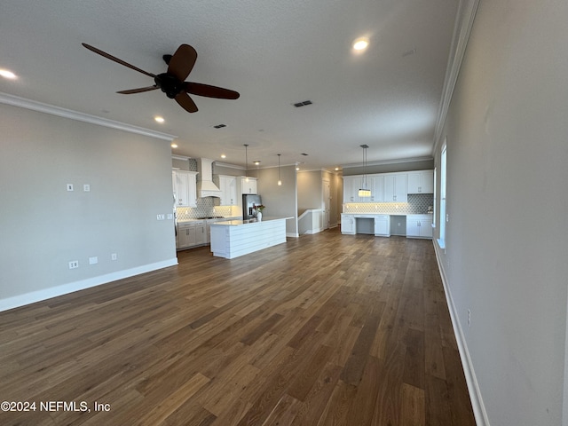 unfurnished living room with ornamental molding, ceiling fan, and dark hardwood / wood-style flooring