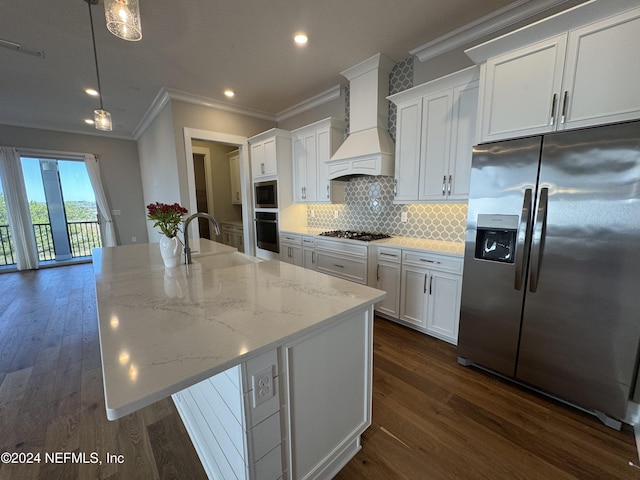 kitchen featuring premium range hood, sink, appliances with stainless steel finishes, an island with sink, and pendant lighting