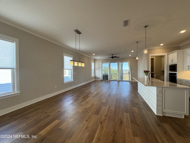 unfurnished living room featuring ornamental molding, sink, a textured ceiling, and dark hardwood / wood-style flooring