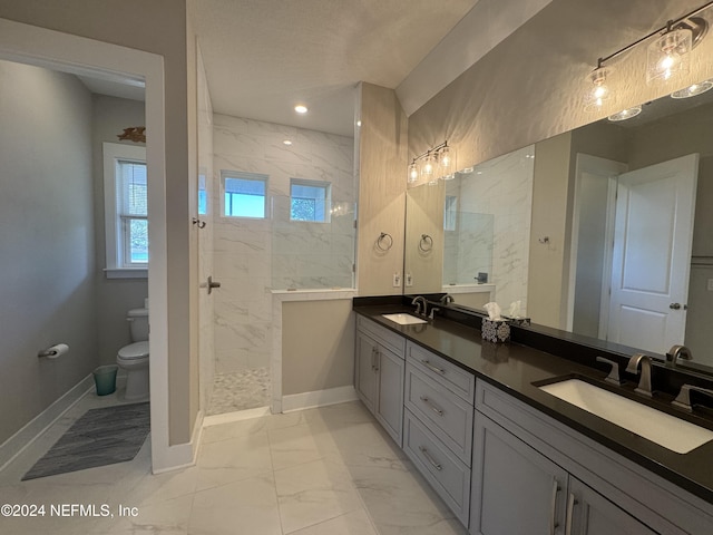 bathroom featuring vanity, toilet, and tiled shower