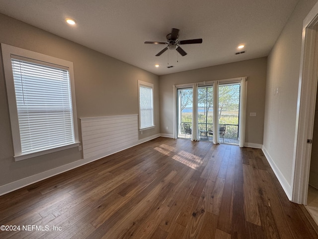 empty room with dark wood-type flooring and ceiling fan