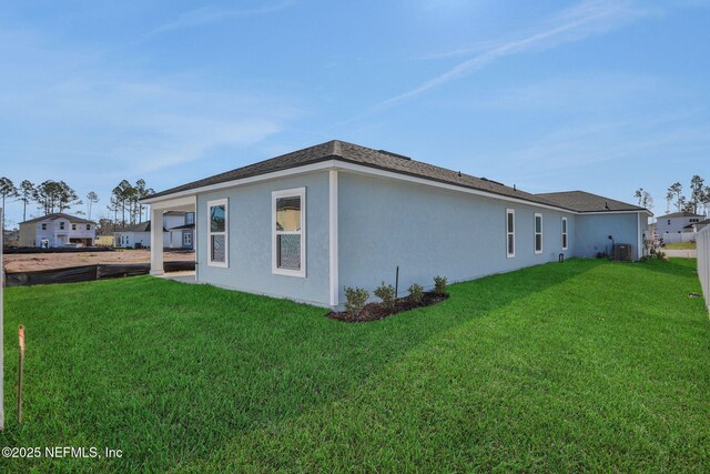 view of side of home with a yard and central air condition unit