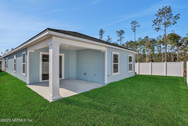 rear view of house with a yard and a patio