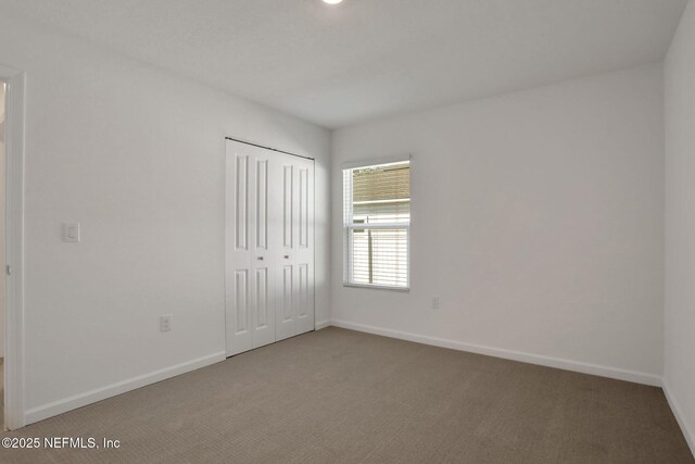 unfurnished bedroom featuring carpet floors and a closet