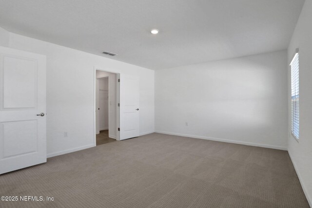 unfurnished bedroom with carpet flooring and a spacious closet