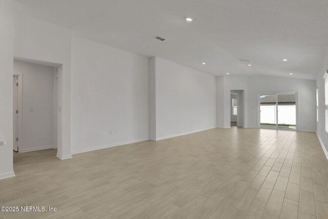 unfurnished living room featuring lofted ceiling and light hardwood / wood-style floors