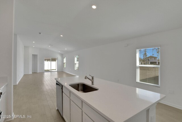 kitchen featuring sink, vaulted ceiling, dishwasher, an island with sink, and white cabinets