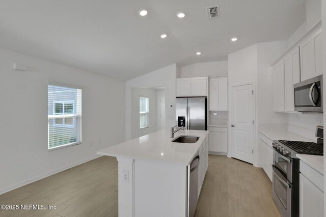 kitchen featuring white cabinetry, appliances with stainless steel finishes, sink, and an island with sink