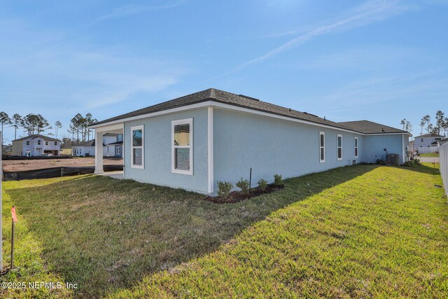 view of side of home featuring a lawn and central air condition unit