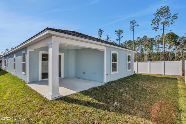 rear view of house with a patio and a yard