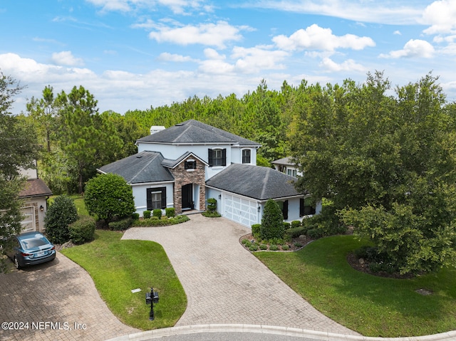 view of front of property with a garage and a front lawn