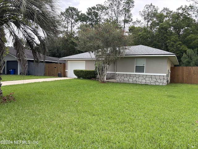 1555 Ibis Dr, Orange Park, FL 32065 - ranch-style home with a garage, fence, stone siding, a front yard, and driveway
