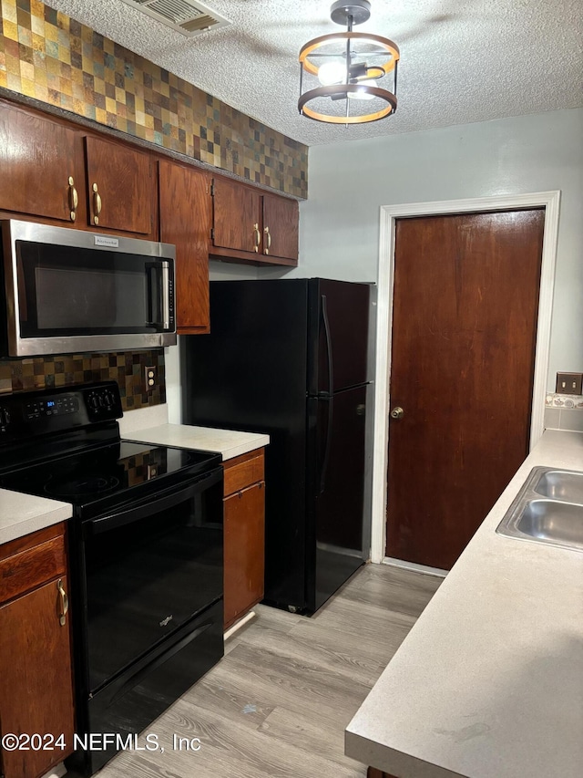 1555 Ibis Dr, Orange Park, FL 32065 - kitchen with visible vents, light wood-style floors, light countertops, a sink, and black appliances