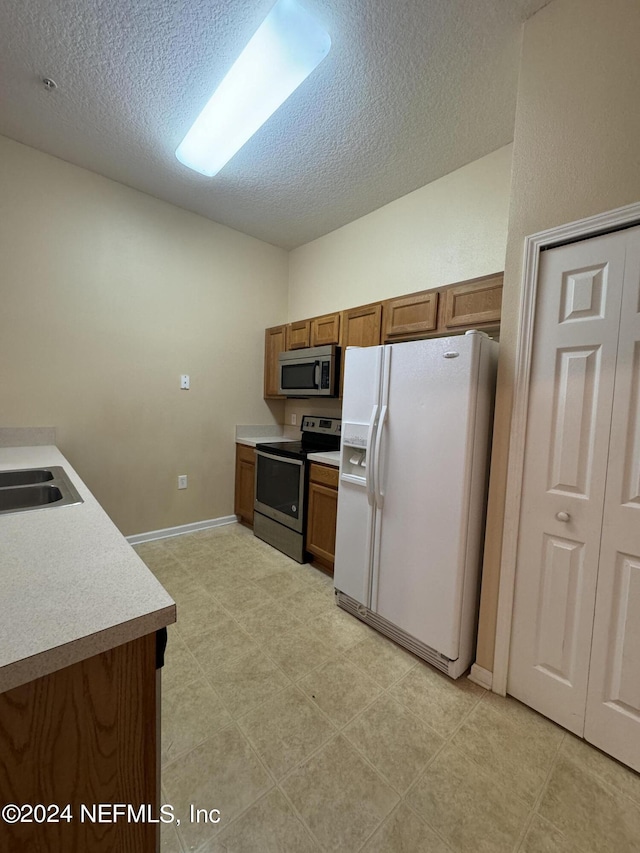 kitchen featuring sink, stainless steel appliances, and a textured ceiling