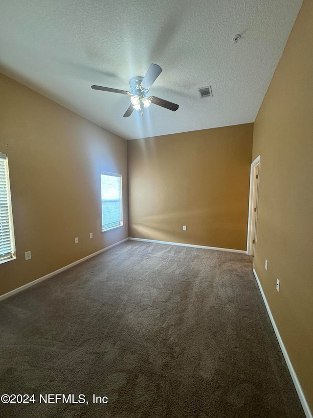 spare room featuring ceiling fan, a textured ceiling, and carpet flooring