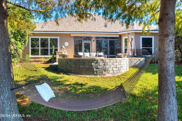 rear view of property featuring a lawn