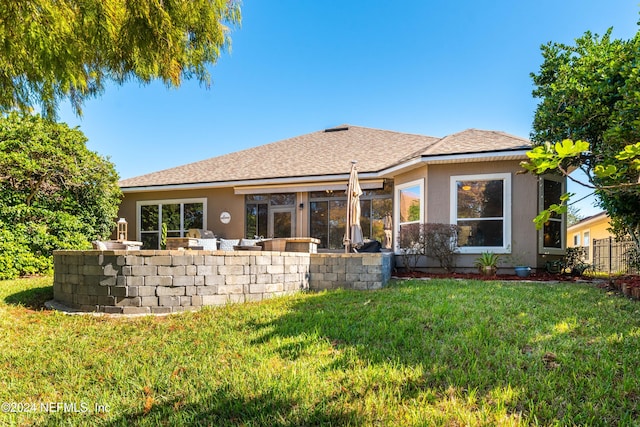 rear view of house with a lawn and an outdoor bar