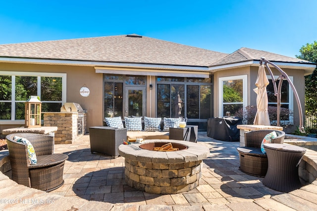 exterior space with a patio area, exterior kitchen, and an outdoor fire pit