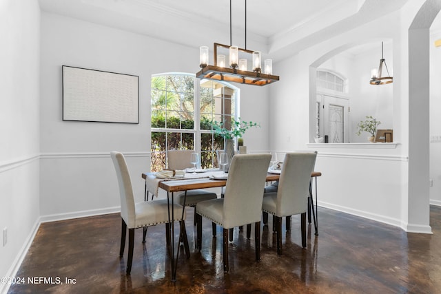 dining space featuring a tray ceiling, ornamental molding, and a notable chandelier