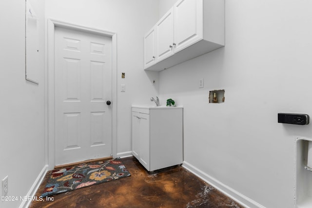 clothes washing area with cabinets, washer hookup, and sink