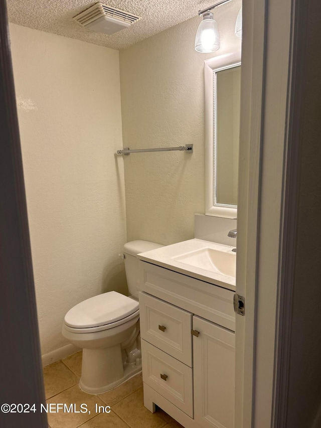 bathroom featuring tile patterned floors, a textured ceiling, vanity, and toilet