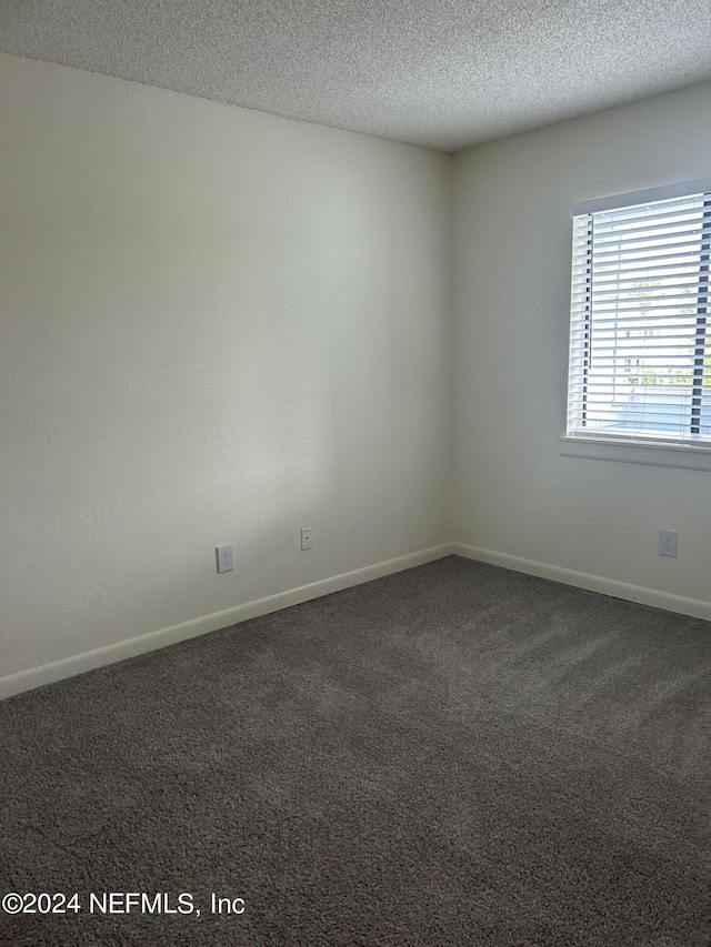 100 Fairway Park Blvd Unit 605, Ponte Vedra Beach, FL 32082 - unfurnished room featuring baseboards, dark colored carpet, and a textured ceiling