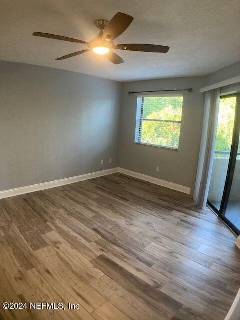 unfurnished room with hardwood / wood-style floors and a textured ceiling