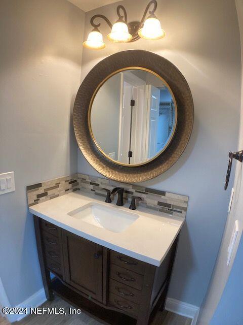 bathroom featuring vanity and backsplash