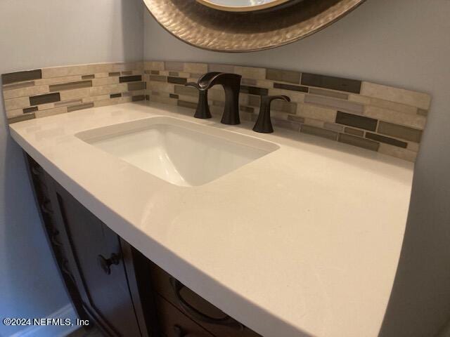 bathroom with tasteful backsplash and vanity