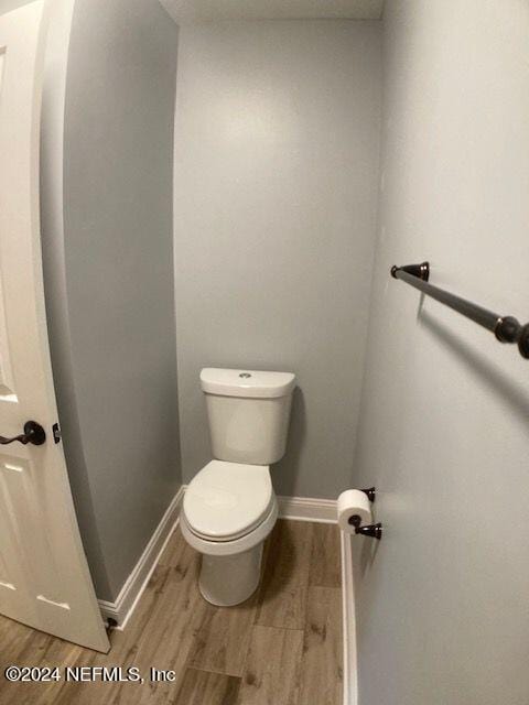 bathroom featuring hardwood / wood-style flooring and toilet