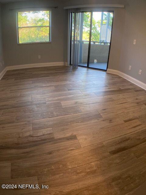 unfurnished room with hardwood / wood-style floors and plenty of natural light