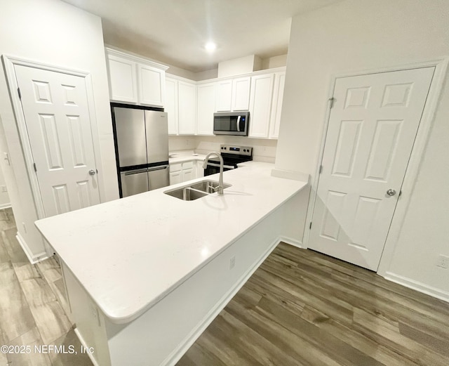 kitchen featuring kitchen peninsula, white cabinetry, and stainless steel appliances