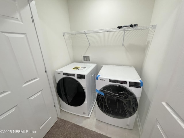 washroom with washing machine and clothes dryer and light tile patterned floors