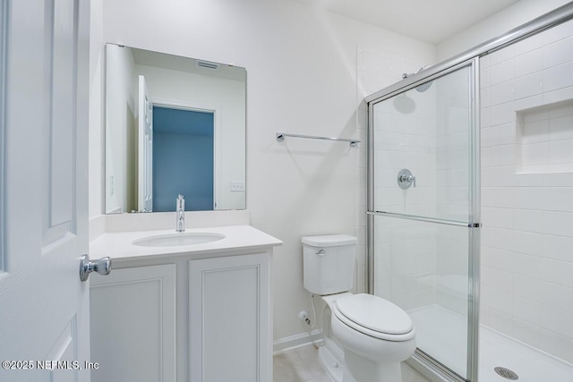 bathroom featuring vanity, toilet, and walk in shower