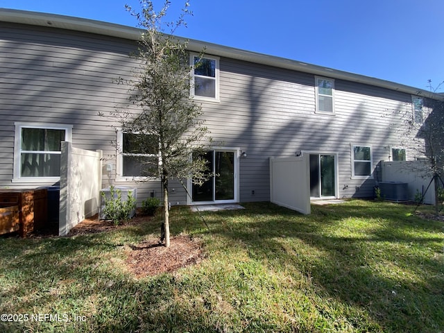 back of house featuring central AC unit and a yard