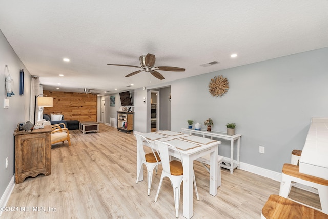 dining space with a textured ceiling, ceiling fan, and light wood-type flooring