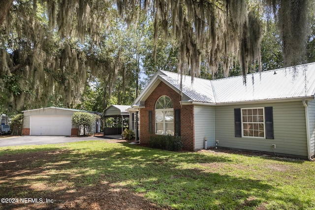 view of front of home featuring a front yard, a garage, a carport, and an outdoor structure