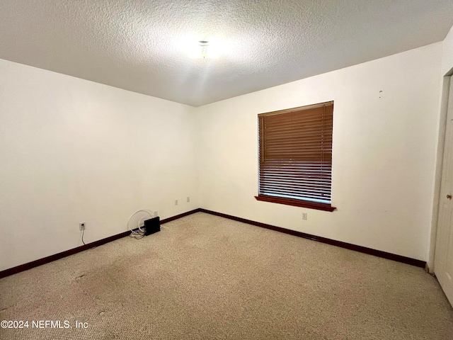 carpeted empty room with a textured ceiling