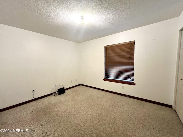 unfurnished room featuring carpet floors and a textured ceiling