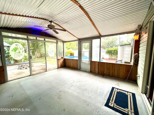 unfurnished sunroom with ceiling fan and vaulted ceiling