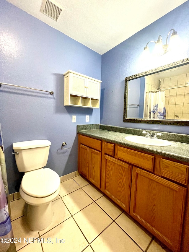 bathroom featuring tile patterned floors, vanity, and toilet