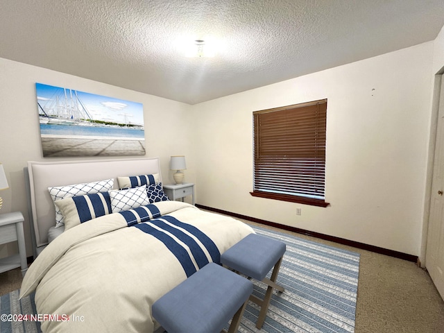 bedroom featuring carpet flooring and a textured ceiling