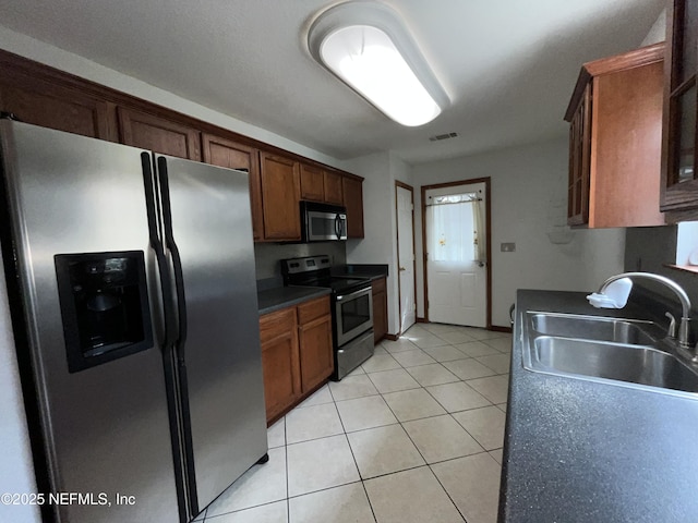 kitchen featuring sink, light tile patterned floors, and stainless steel appliances