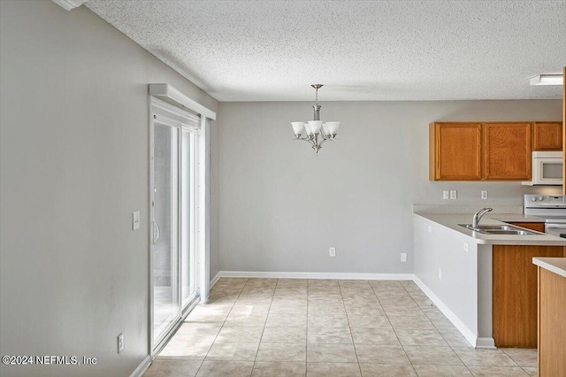 kitchen with sink, a textured ceiling, hanging light fixtures, a notable chandelier, and white appliances