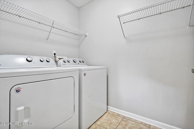 washroom featuring light tile patterned floors and washer and dryer