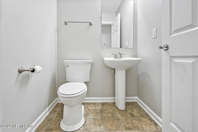 bathroom featuring sink, a textured ceiling, and toilet