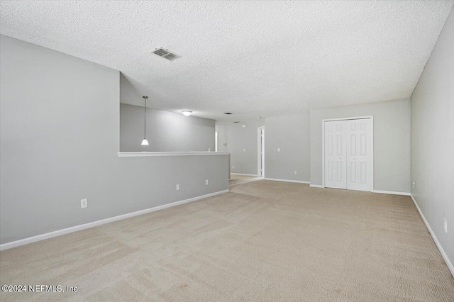 carpeted empty room with a textured ceiling